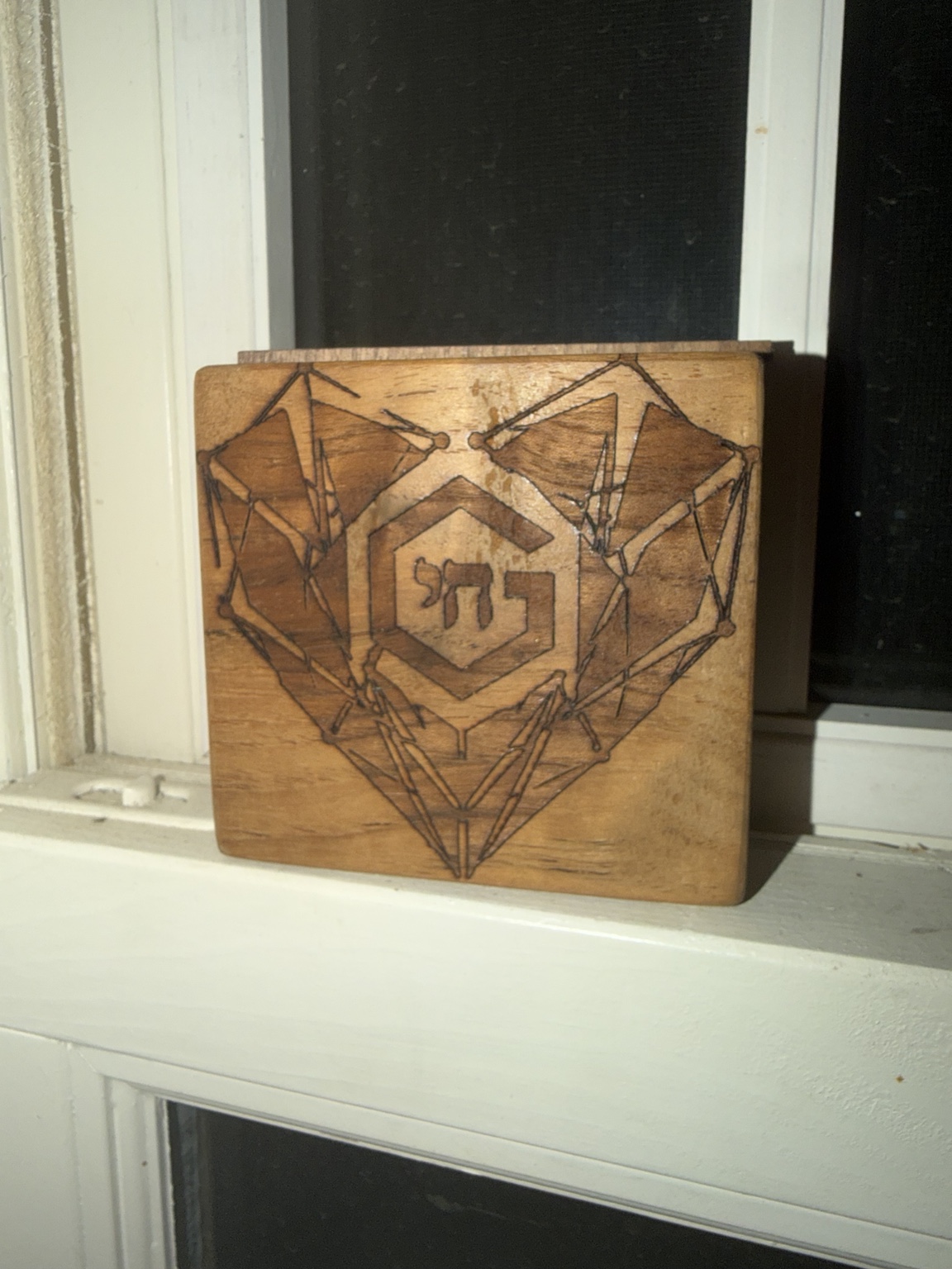 Square wooden plaque engraved with geometric heart imagery and a G Benincasa mark.