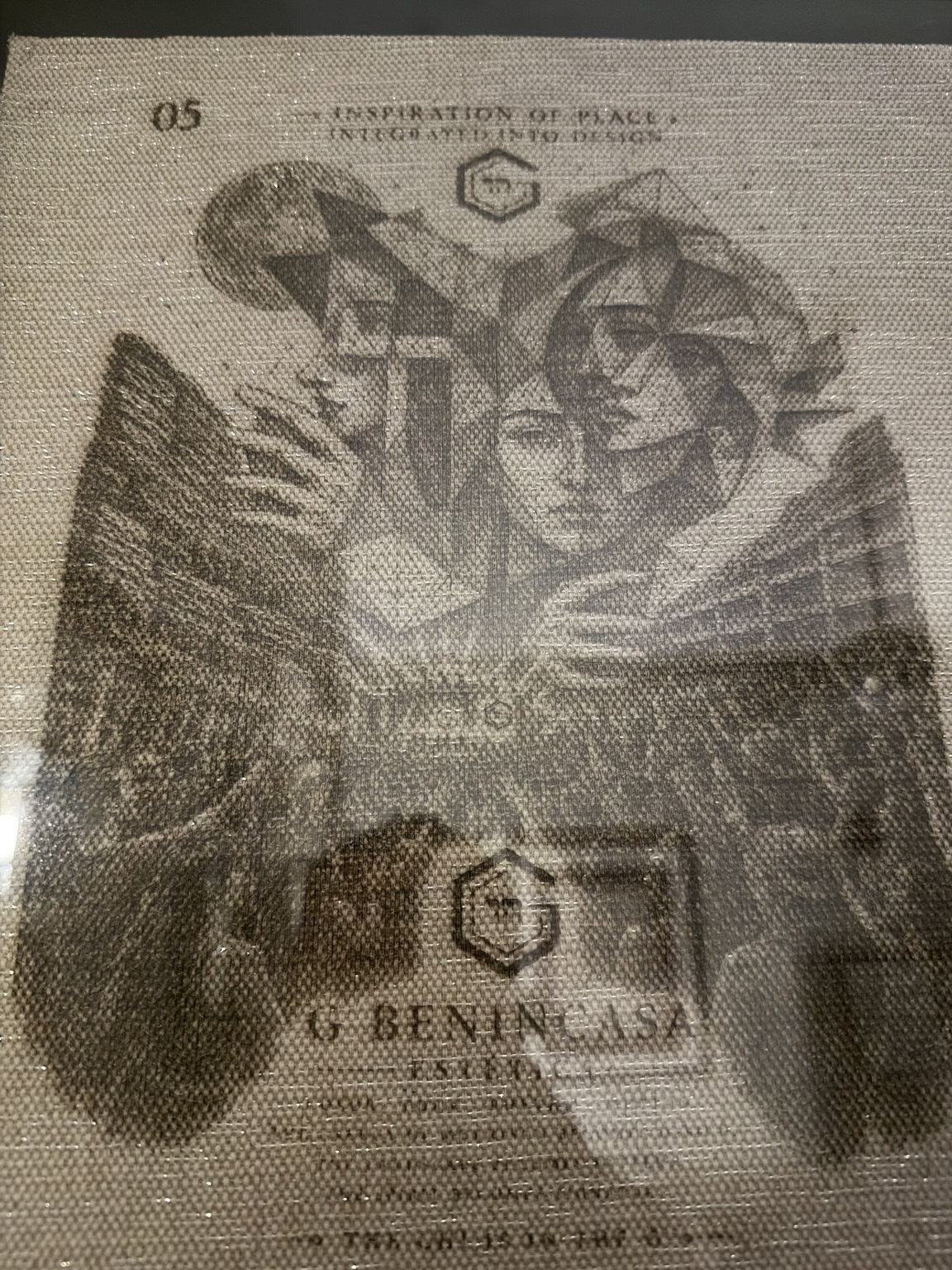 Figurative engraved artwork on a woven ground, with the material texture visible.